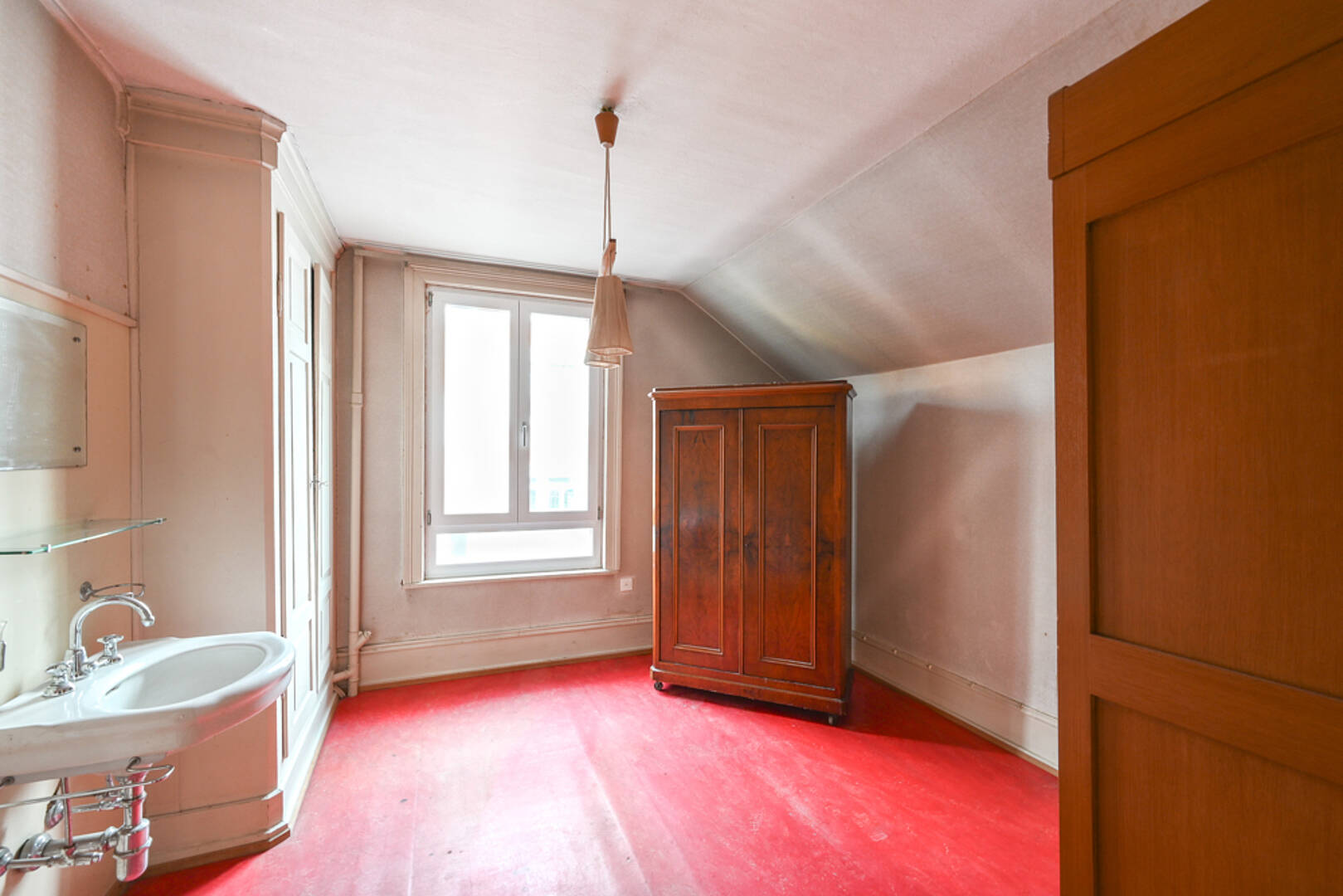 Dachzimmer mit Waschbecken und Schrank