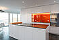 Moderne Küche mit orangefarbener Rückwand
