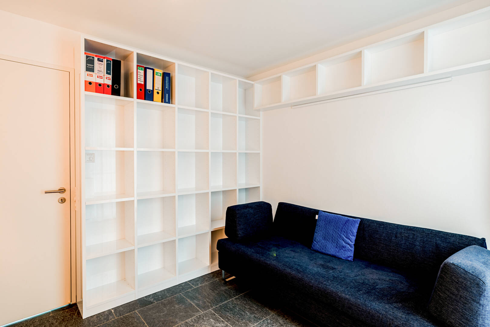 Arbeits- oder Gästezimmer mit Sofa und Einbauregal