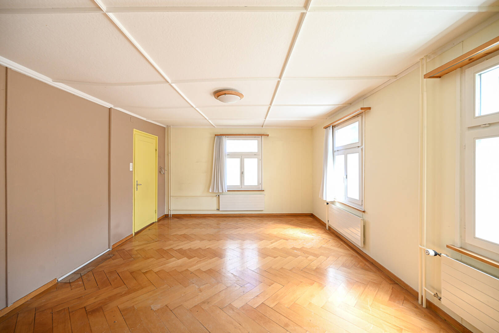 Heller, leerer Wohnraum mit Holzparkett