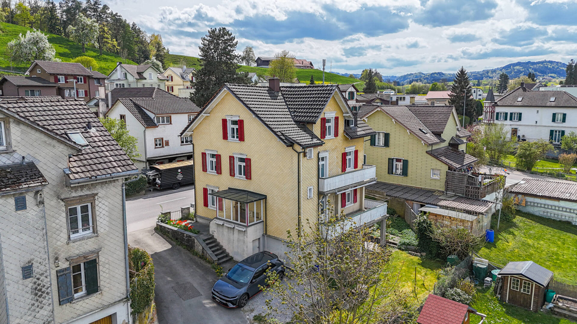 Wohnhäuser in grüner Hügellandschaft