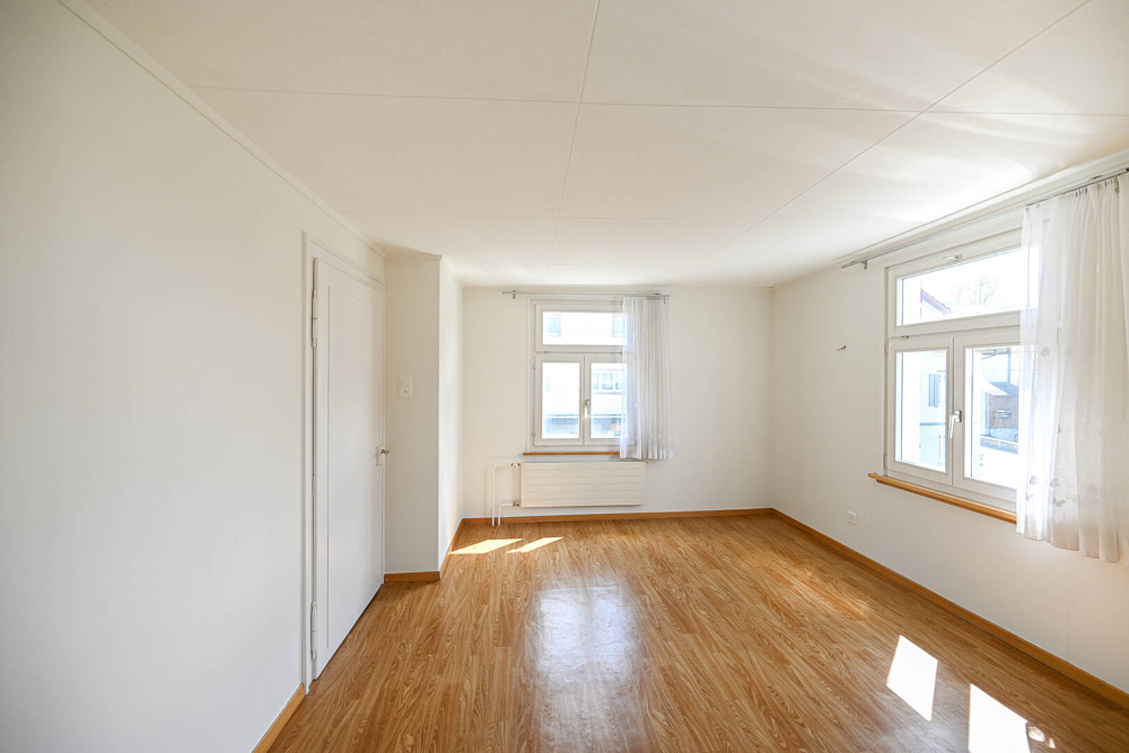 Heller leerer Wohnraum mit Holzoptikboden