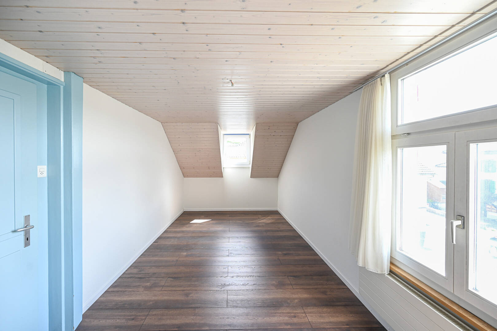 Heller Dachraum mit schräger Holzdecke