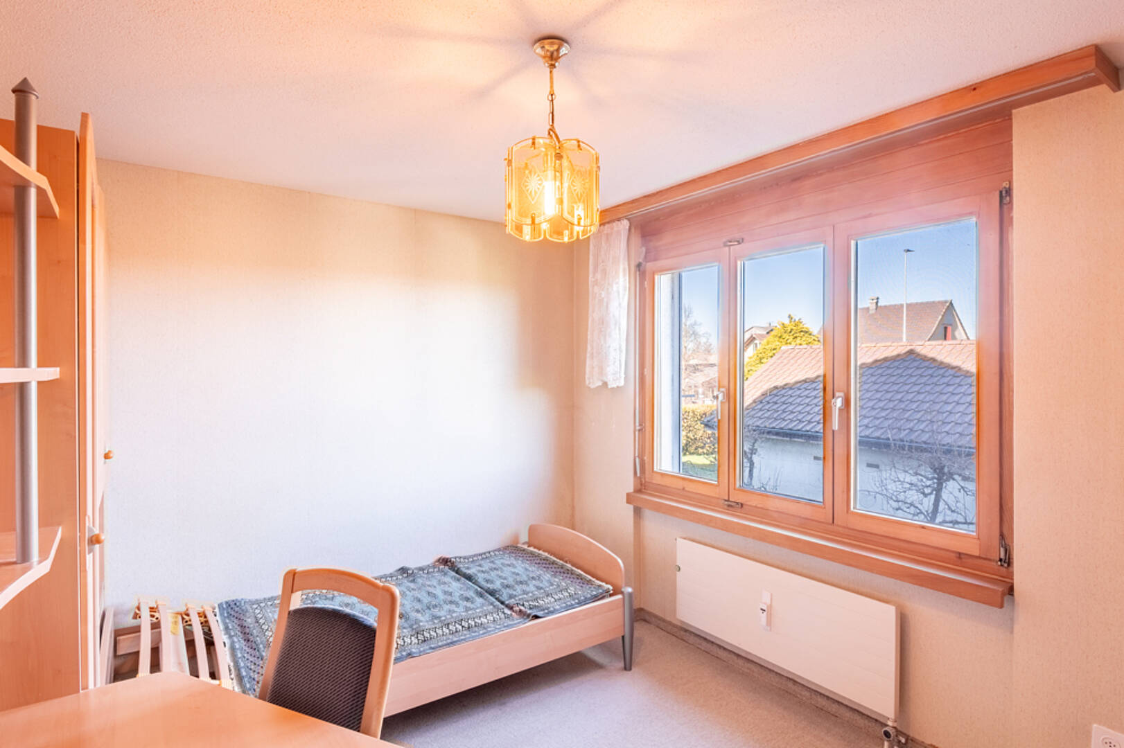 Helles Schlafzimmer mit Holzfenster und Einzelbett