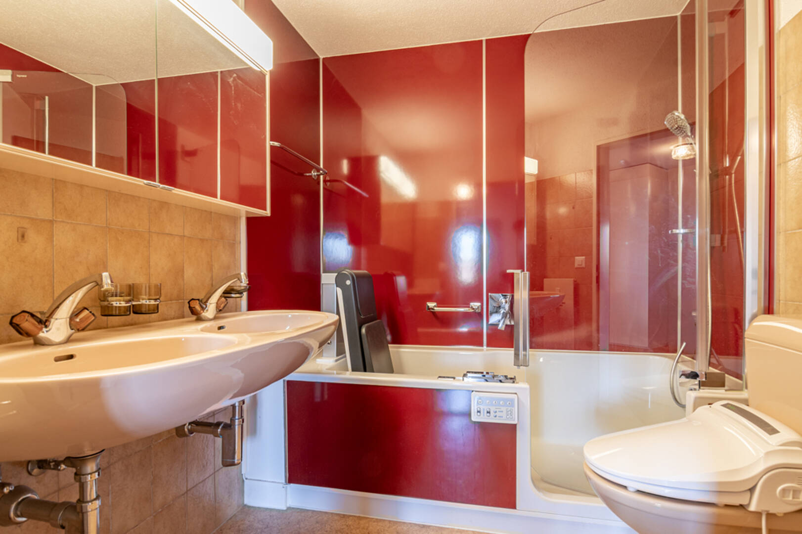 Kleines Badezimmer mit Badewanne und roter Wandverkleidung