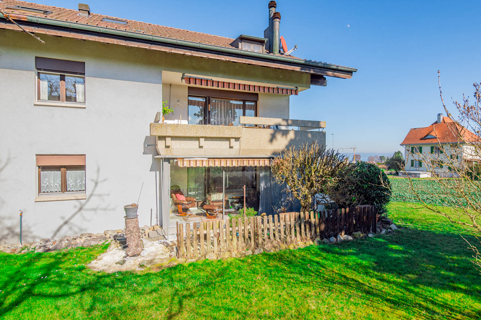Hausaußenansicht mit Garten und Balkon