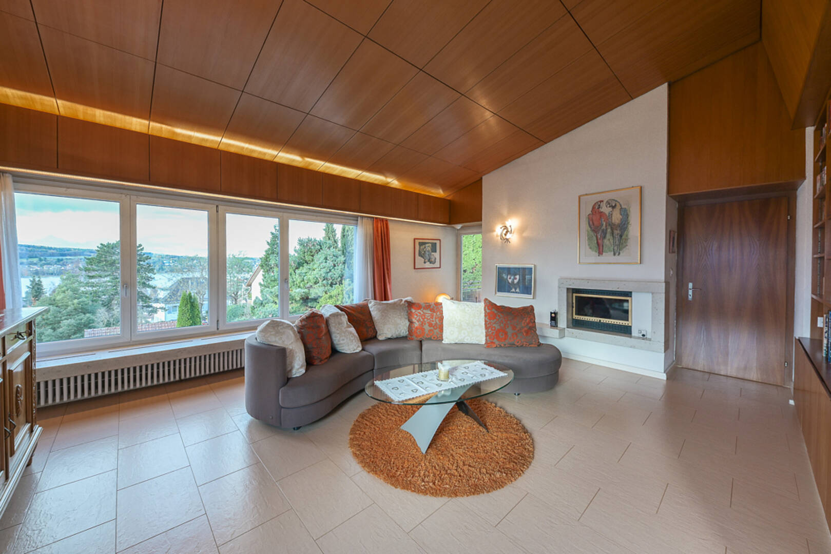 Wohnzimmer mit Panoramafenstern und Kamin