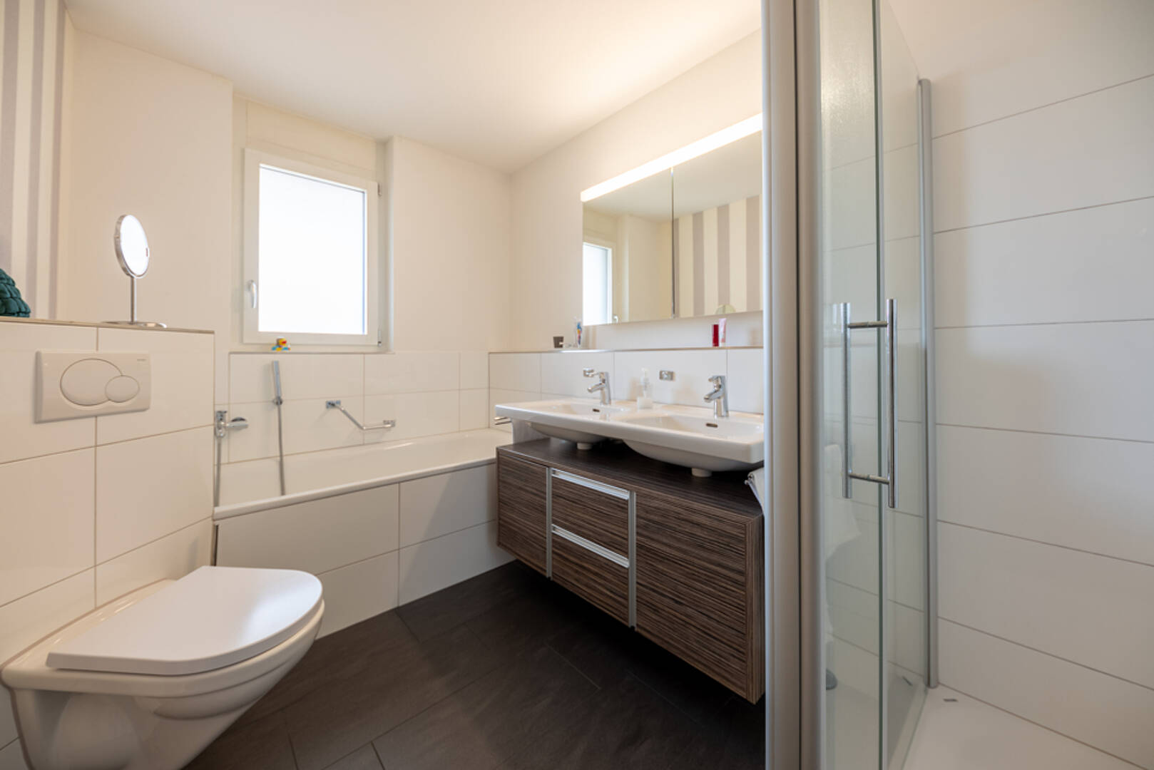 Modernes Badezimmer mit Wanne, Doppelwaschbecken und Glasdusche