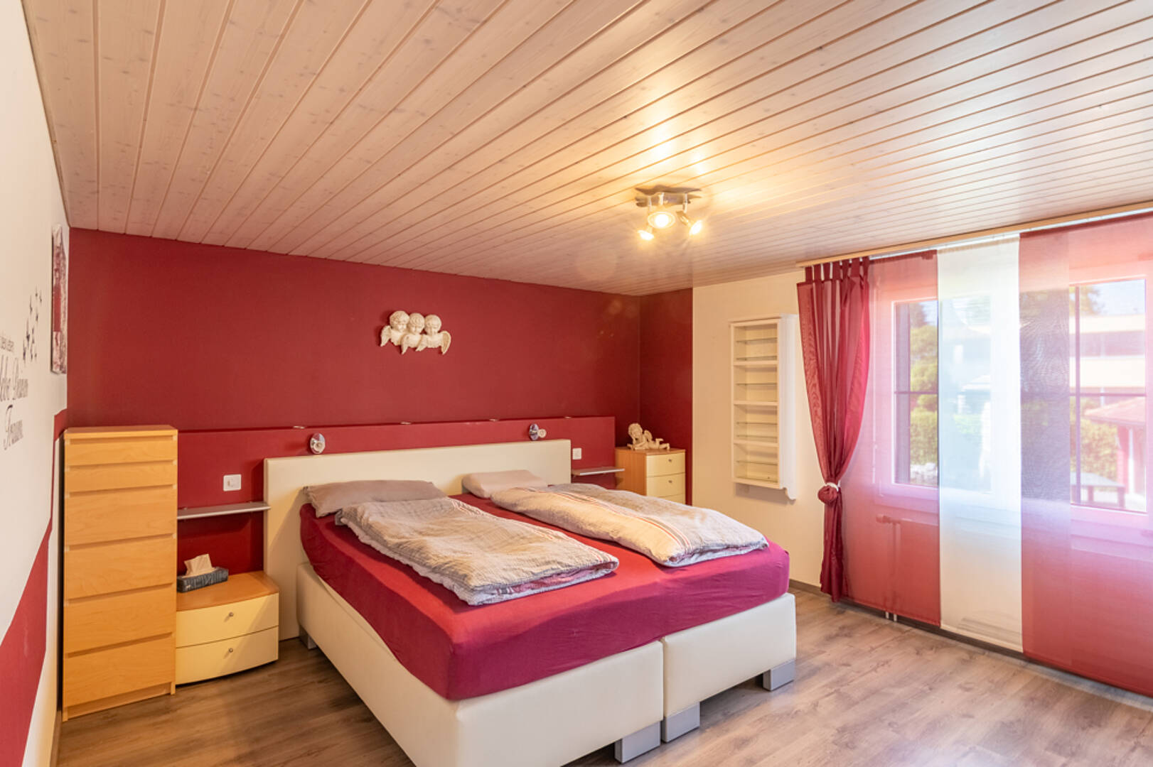 Schlafzimmer mit Doppelbett und viel Rot