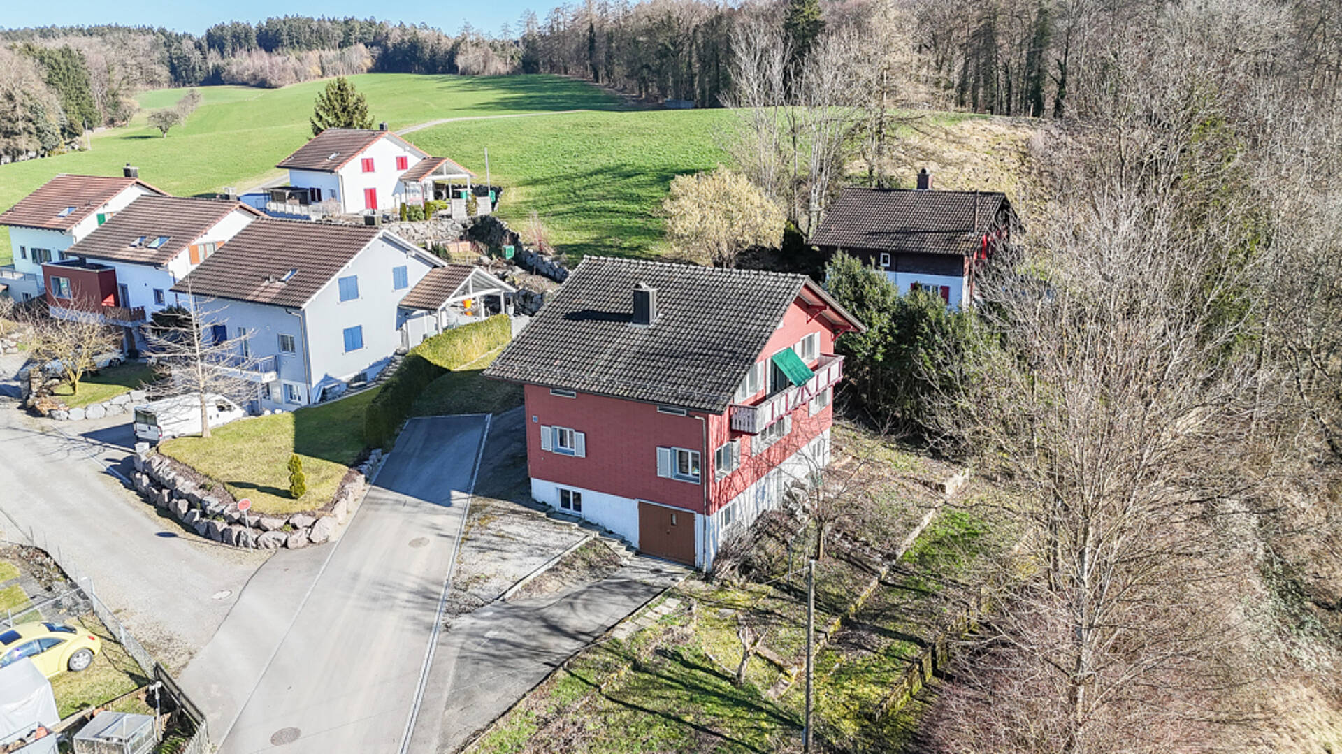 Luftaufnahme eines Wohngebiets in grüner Hanglage