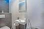 Kleines helles Badezimmer mit Waschtisch und Dusche