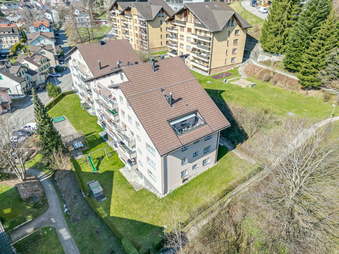 Luftaufnahme eines Mehrfamilienhauses mit Garten