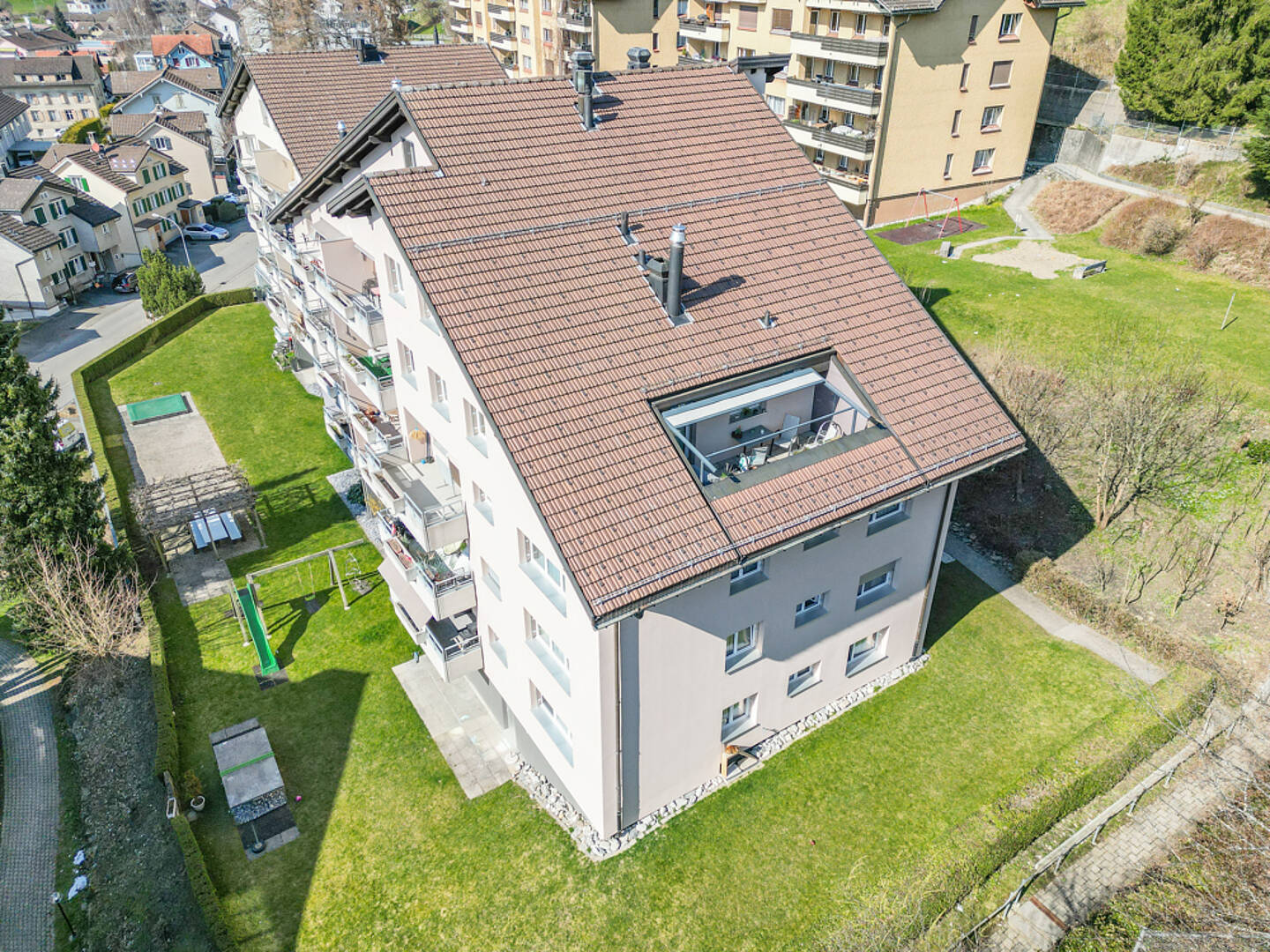Luftaufnahme eines Mehrfamilienhauses mit Garten