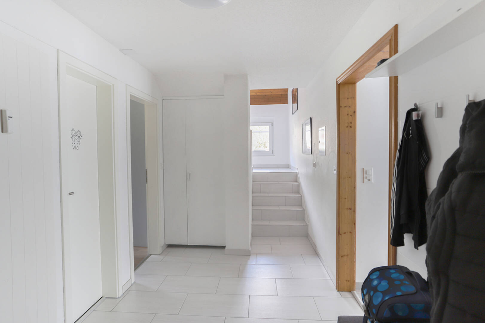 Heller Eingangsbereich mit Treppe und WC-Tür