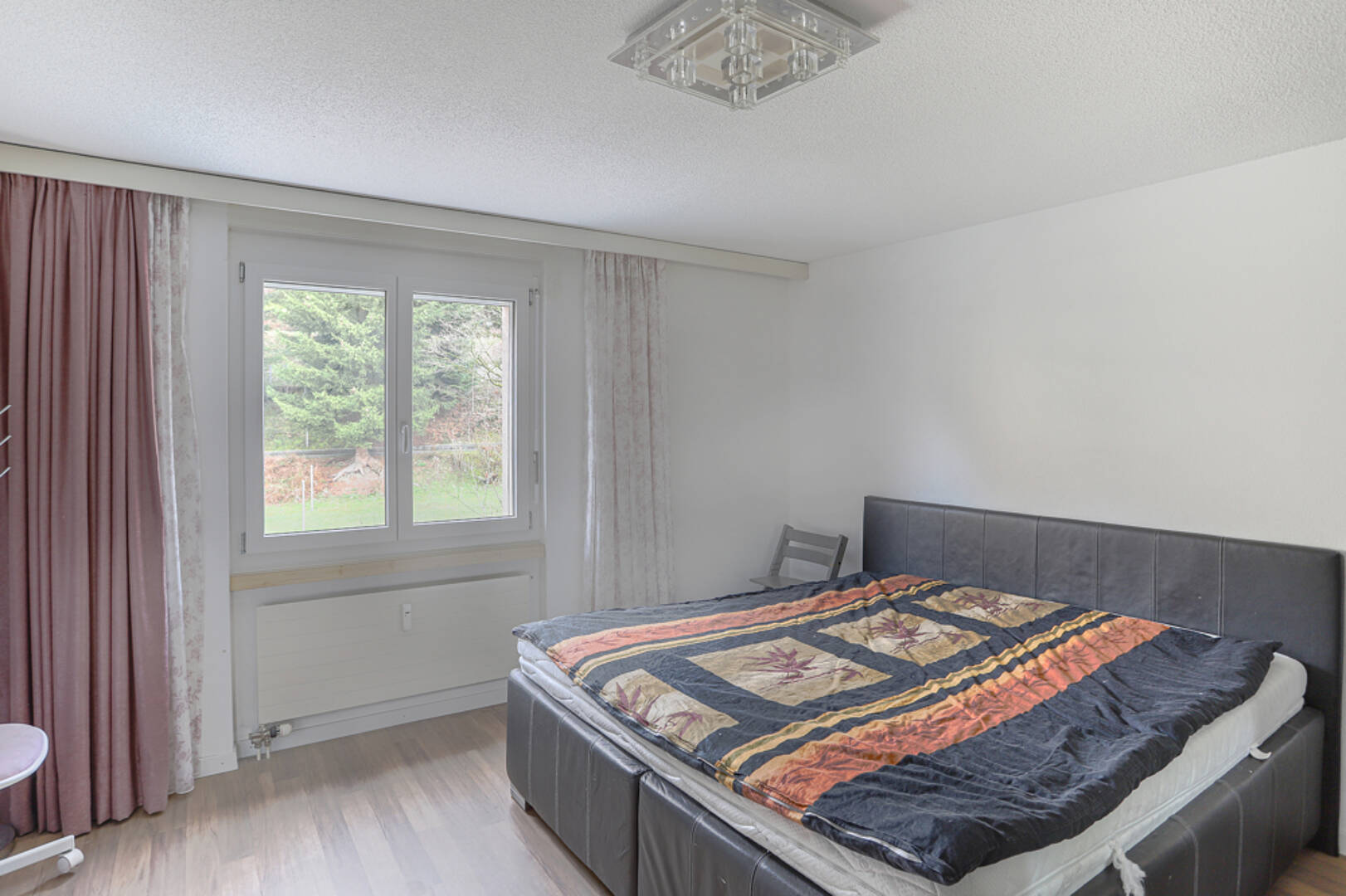 Schlafzimmer mit Bett und Fensterblick