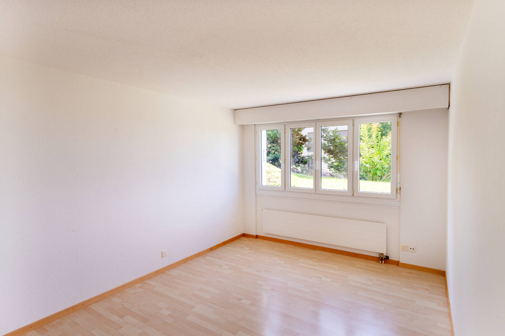 Heller leerer Wohnraum mit Fenster und Heizkörper