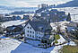 Schneebedecktes Wohnhaus mit See- und Bergblick
