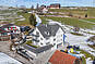 Außenansicht einer Baustelle mit Fundament und Kranteilen