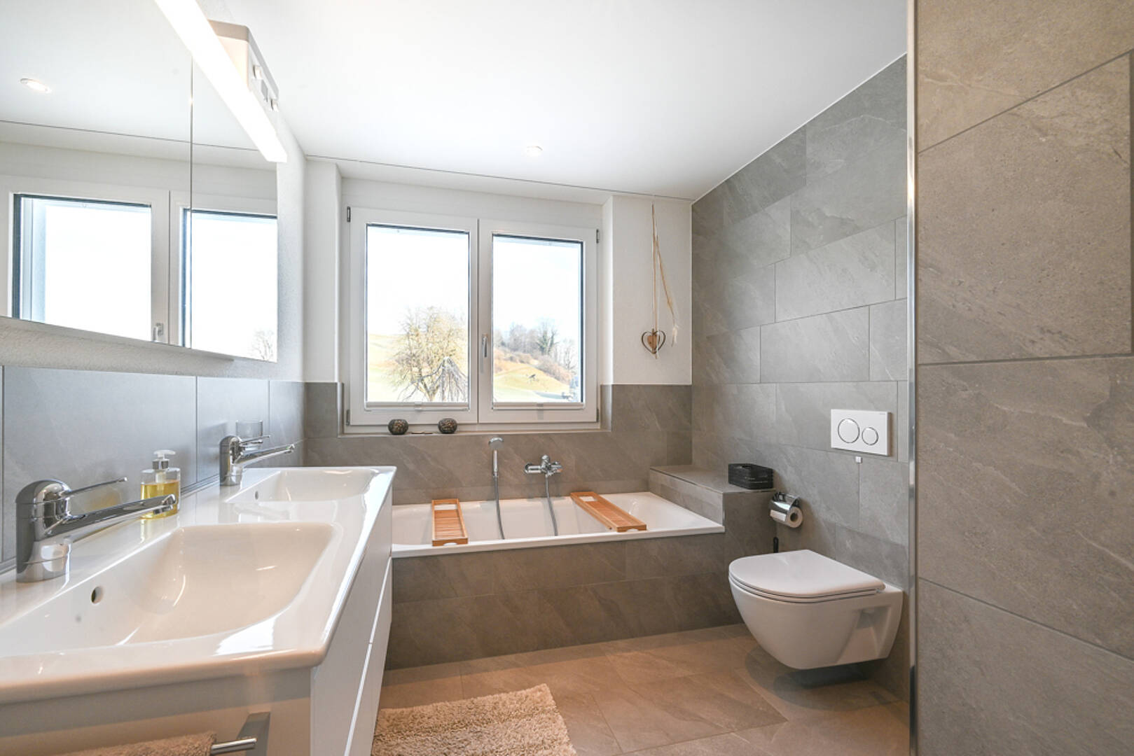Modernes Badezimmer mit Wanne, Doppelwaschbecken und WC