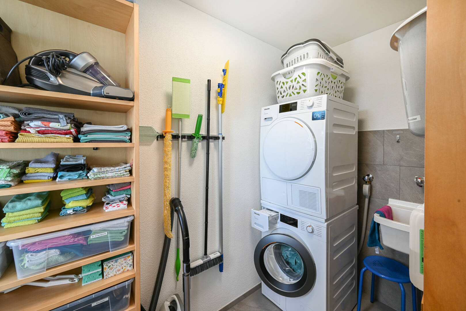 Hauswirtschaftsraum mit Waschmaschine und Wäschelager