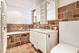 Badezimmer mit Eckbadewanne und Mosaikfliesen