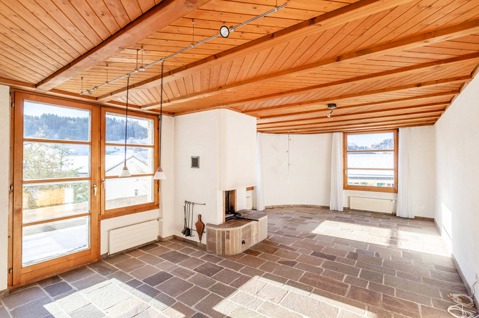 Heller Wohnraum mit Holzdecke und Natursteinboden