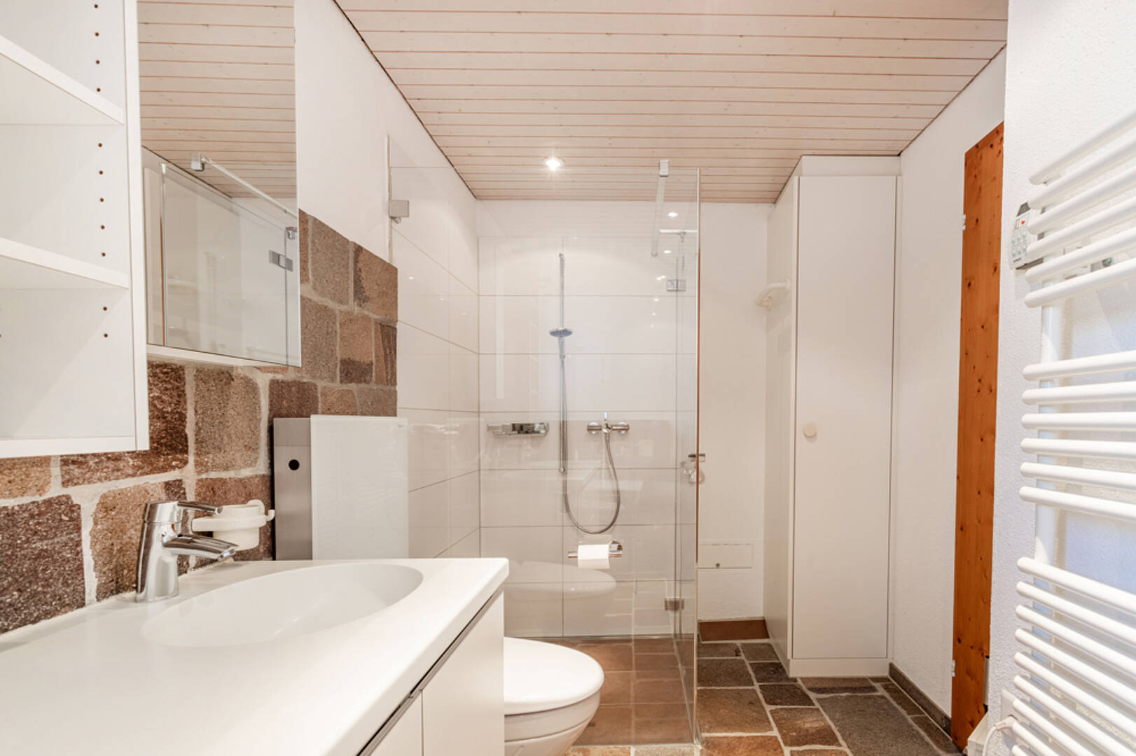 Modernes Badezimmer mit Dusche und Natursteinwand
