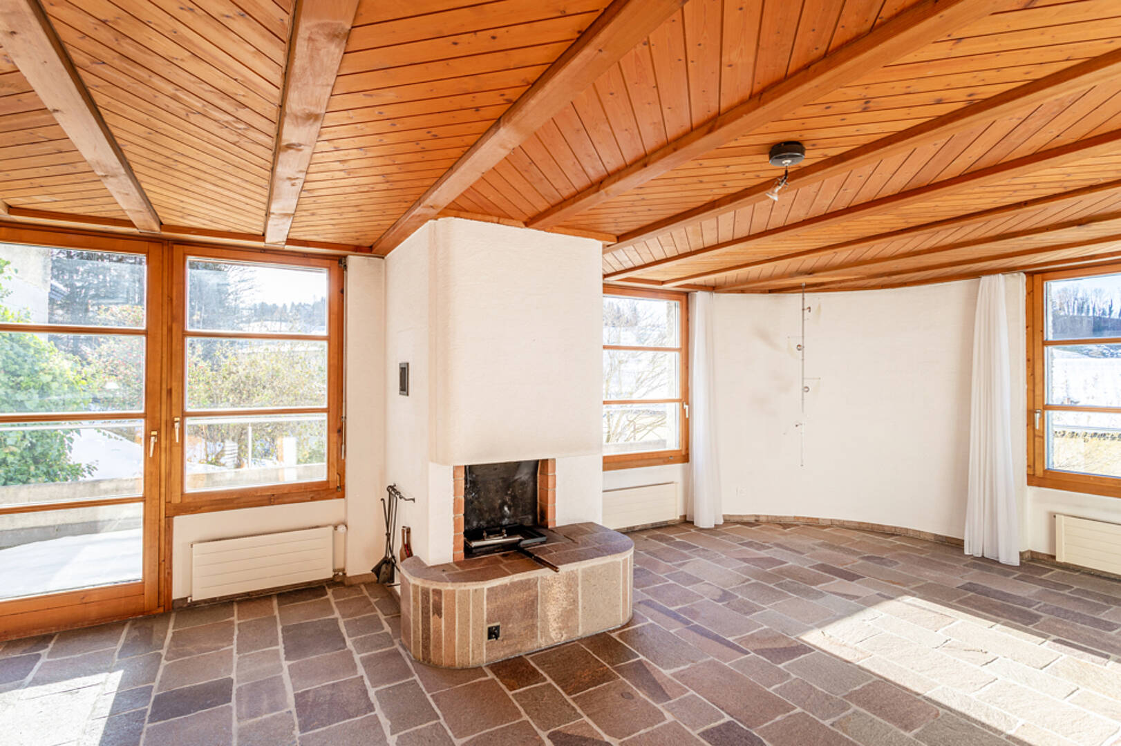 Heller Wohnraum mit Kamin und Holzbalkendecke