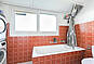 Badezimmer mit Badewanne und roter Fliesenverkleidung
