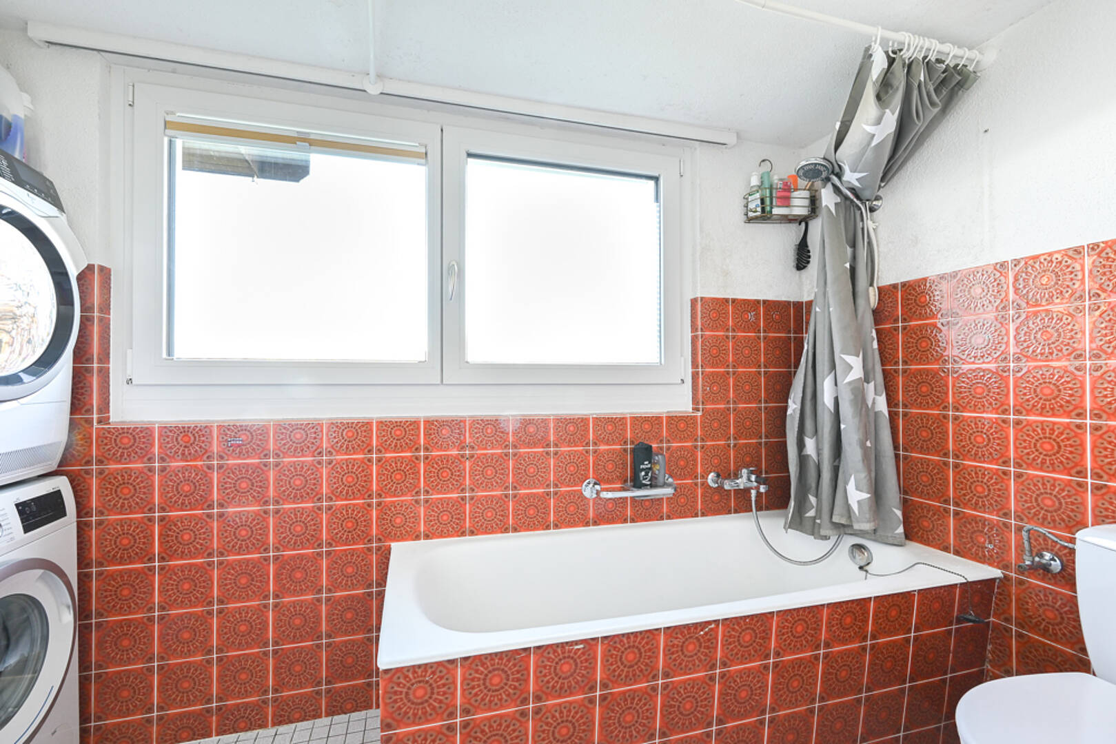 Badezimmer mit orangefarbenen Fliesen und Badewanne