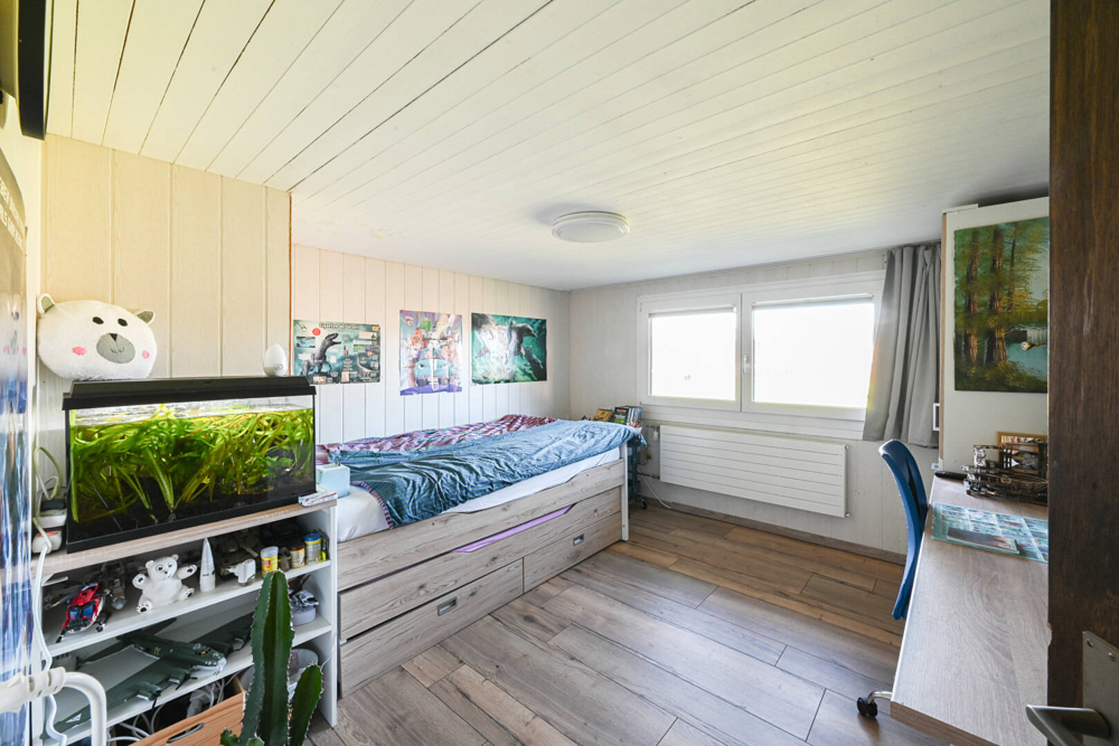 Helles Kinderzimmer mit Bett, Aquarium und Schreibtisch