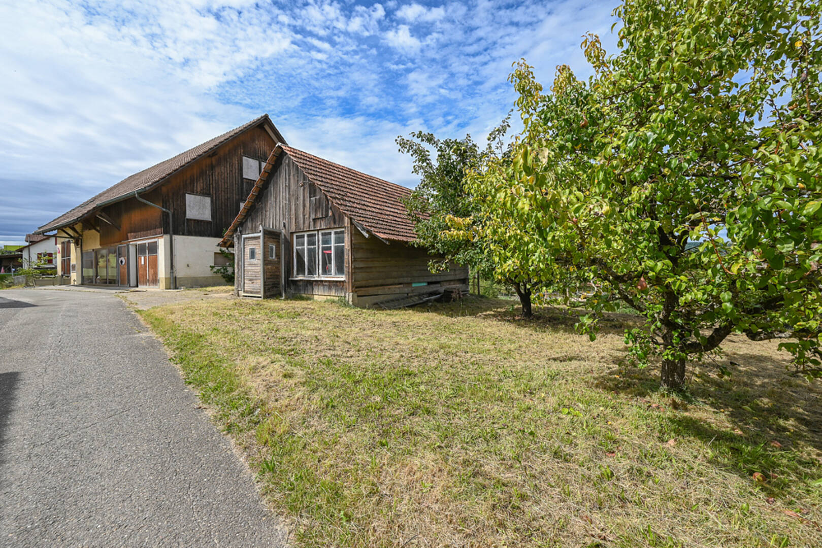 Ländliches Holzgebäude mit Hof und Obstbäumen