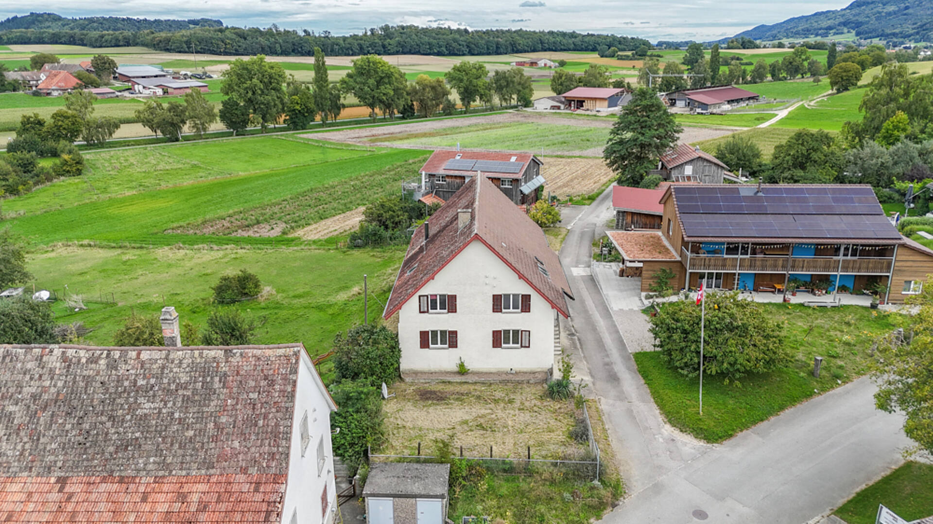 Luftaufnahme eines ländlichen Anwesens mit Bauernhäusern und Feldern