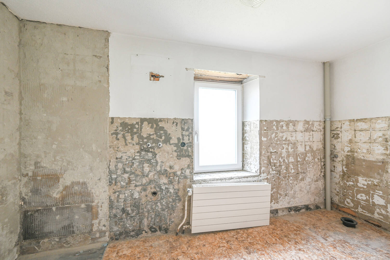 Sanierungsbedürftiger Innenraum mit freigelegten Wänden
