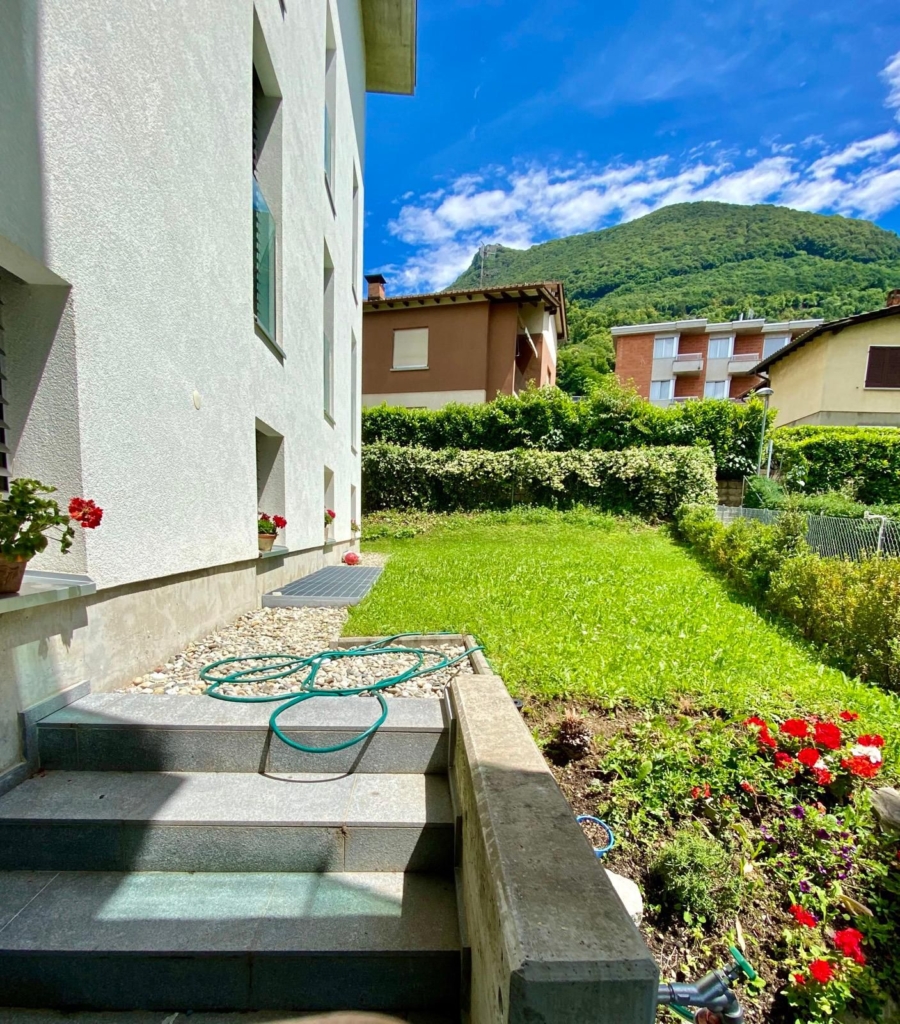 Garten mit Hausfassade und Bergblick