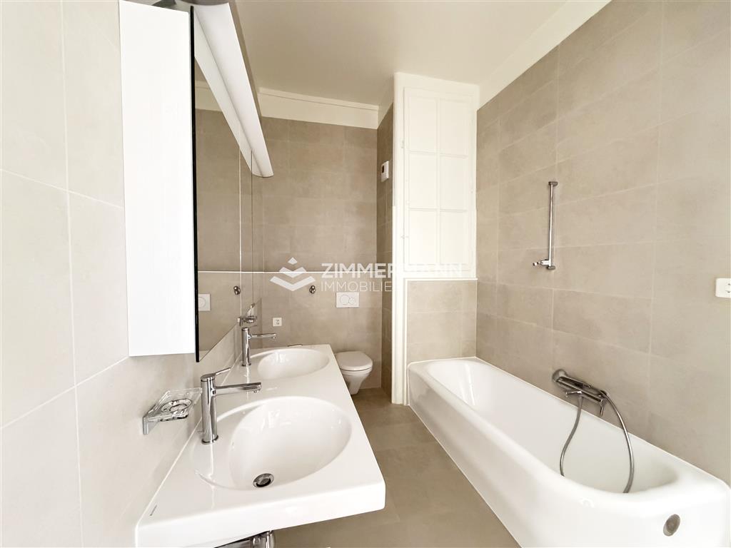 Helles Badezimmer mit Doppelwaschtisch und Badewanne