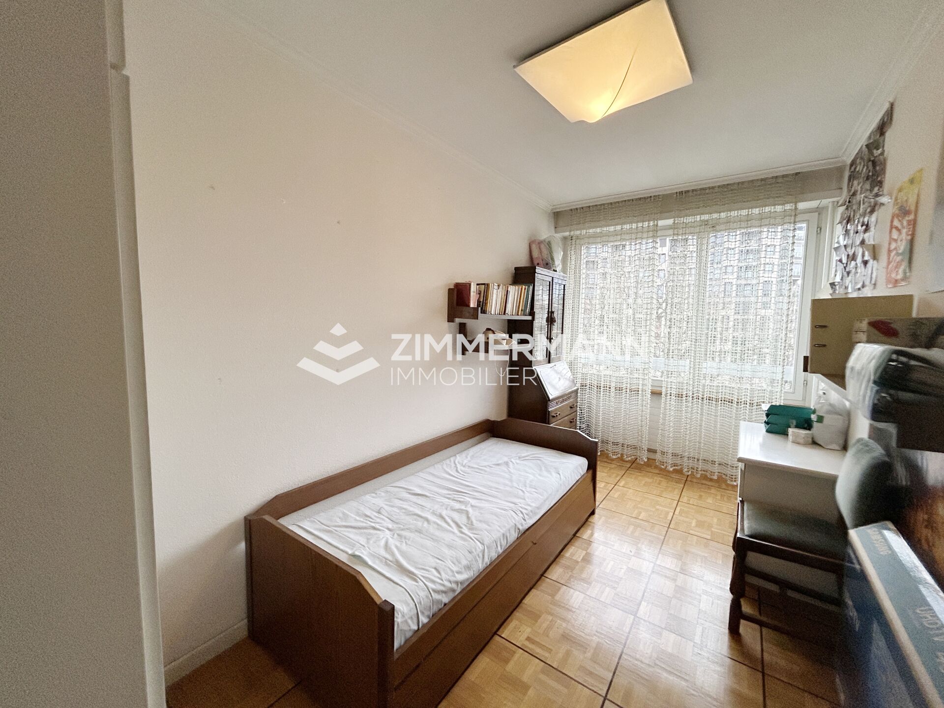 Schmales Schlafzimmer mit Einzelbett und Balkonfenster
