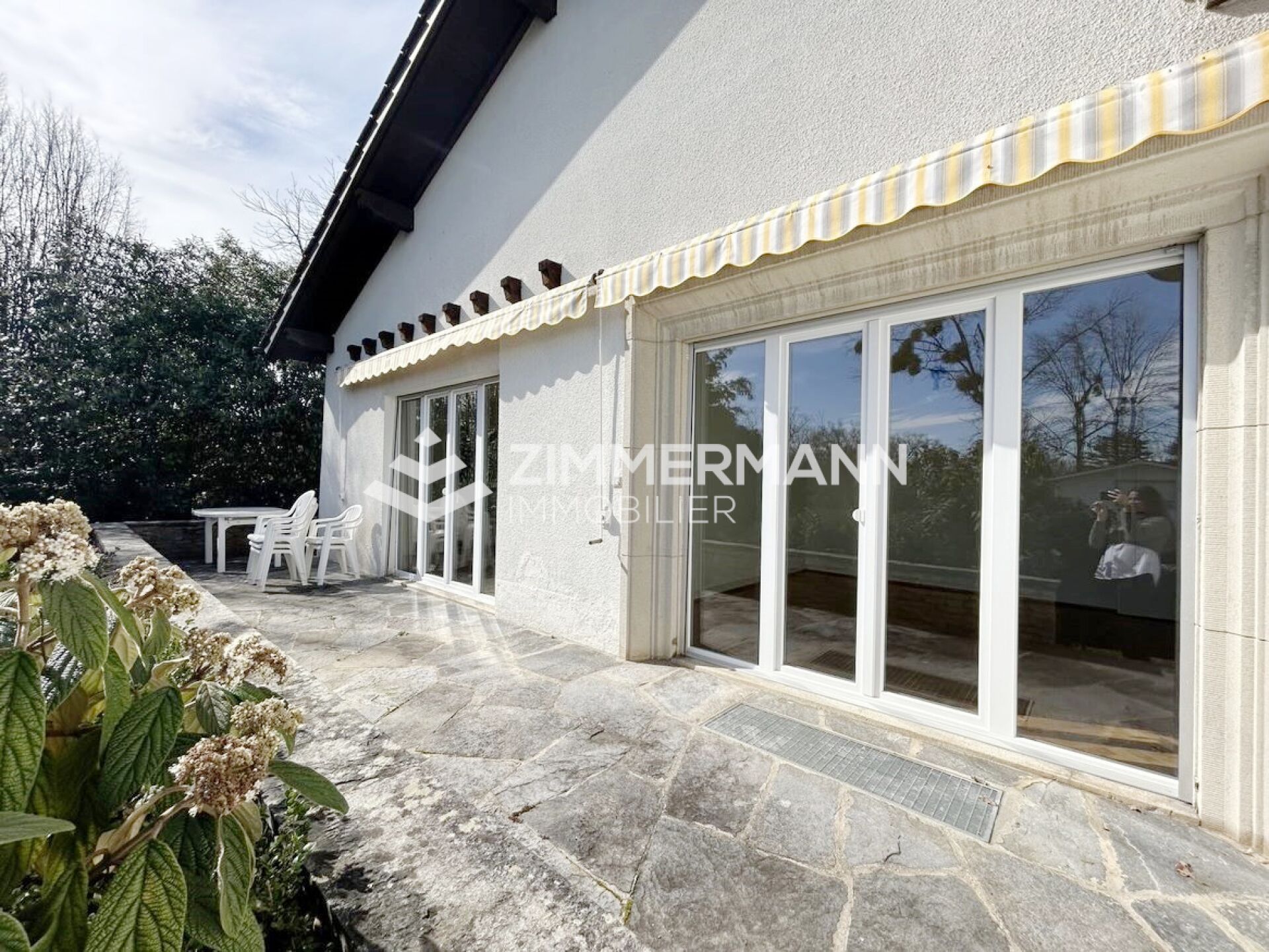 Terrasse an weißem Haus mit großen Schiebetüren