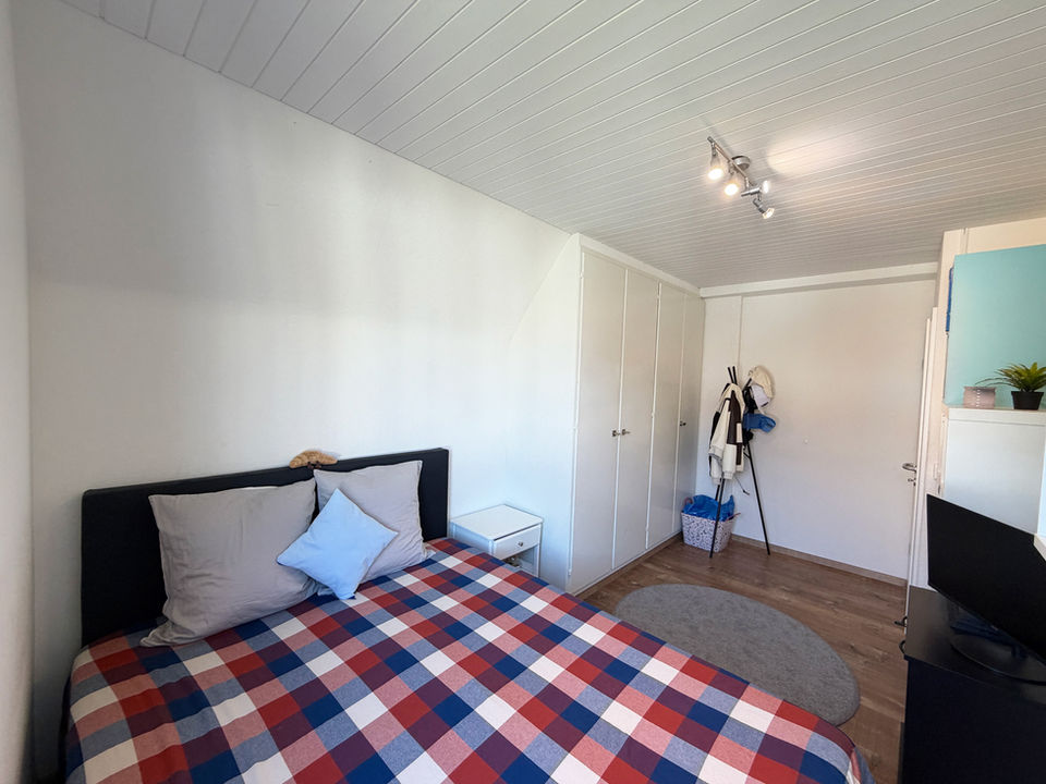 Kleines Schlafzimmer mit Einzelbett und Schrankwand