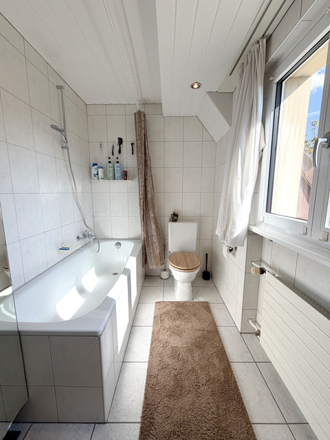 Helles Badezimmer mit Badewanne und WC