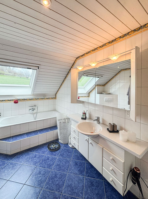 Badezimmer unter dem Dach mit Badewanne und Waschtisch