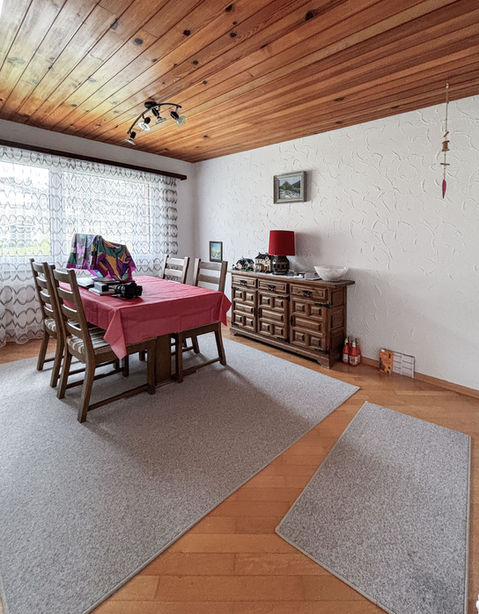 Esszimmer mit Holzbalkendecke und Teppichen