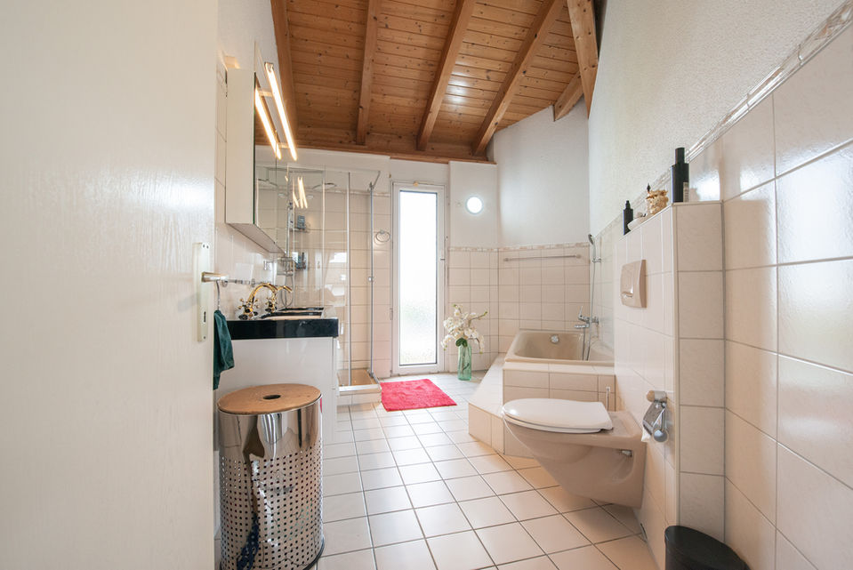 Helles Badezimmer mit Holzdecke