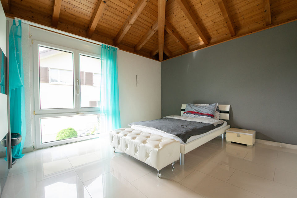 Schlafzimmer mit Holzdecke und großen Fenstern