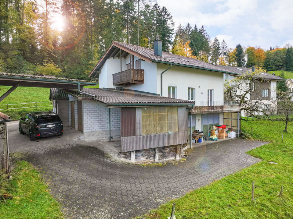 Außenansicht eines Hauses am Hang mit Garage und Balkon