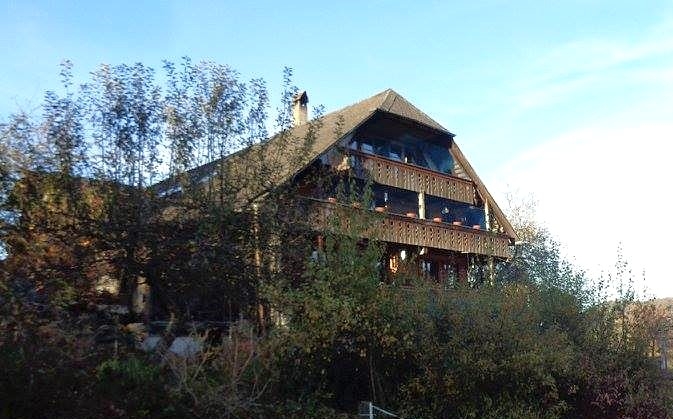 Holzhaus mit steilem Satteldach und Balkonen