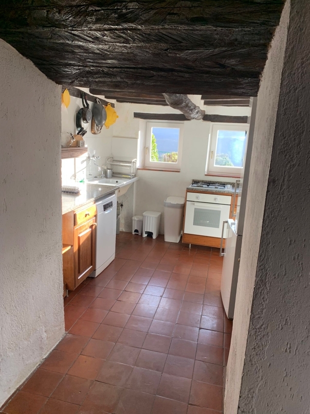 Rustikale, kleine Küche mit Terrakottafliesen und sichtbaren Holzbalken