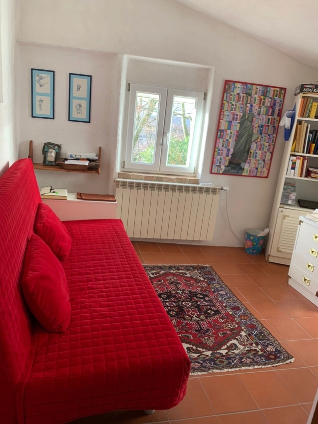 Gemütliches kleines Zimmer mit rotem Sofa