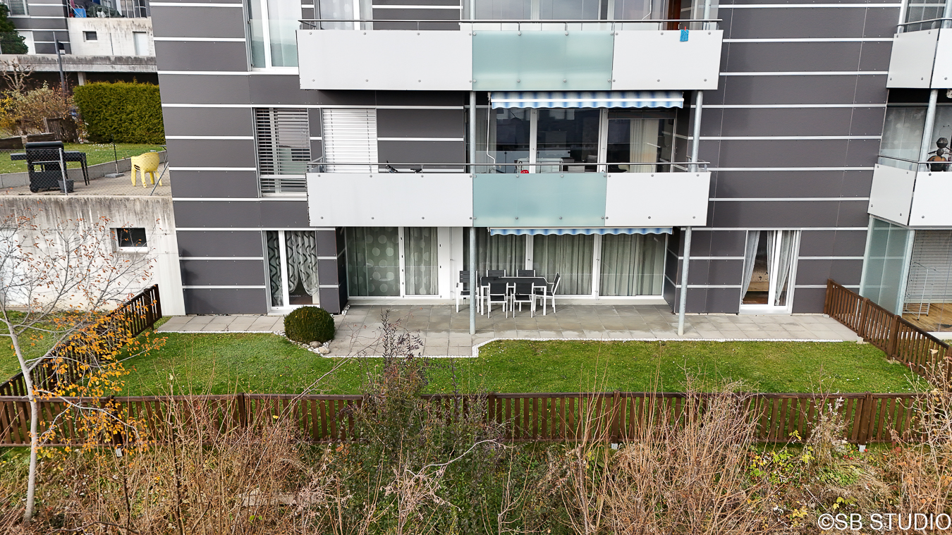 Außenansicht eines modernen Wohngebäudes mit Balkon und Garten