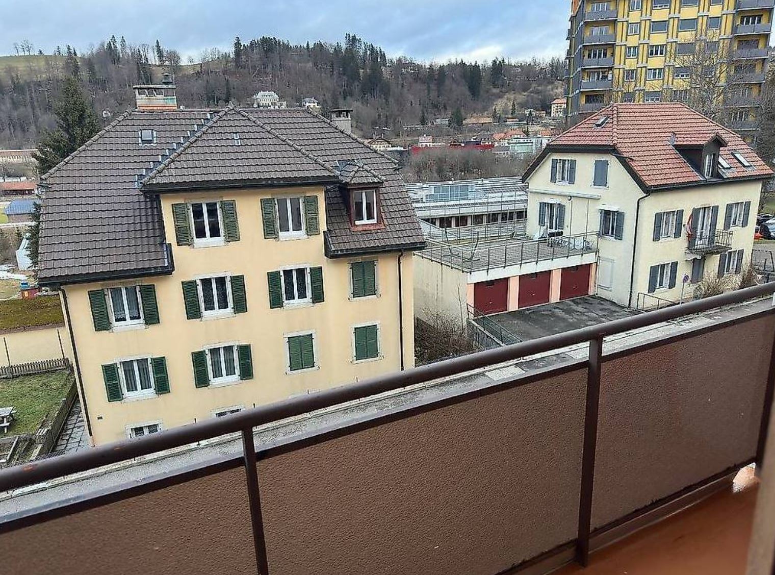 Blick vom Balkon auf Wohnhäuser und Stadtrand